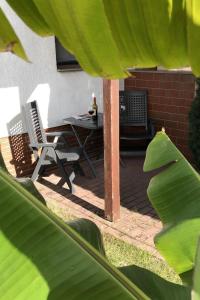 a patio with two chairs and a table with a bottle of wine at Apartment mit Terrasse by Interhome in Mönkebude