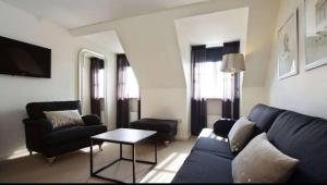 a living room with a blue couch and a table at Starmax City's Hotel YALOVA in Kâzımiye
