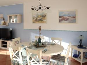 a dining room with a white table and chairs at Apartment Tohus - Wigbold by Interhome in Middelhagen