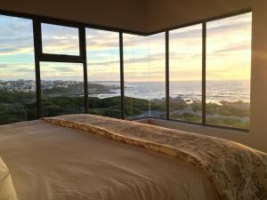 a bedroom with a bed with a view of the ocean at Marine 5 Boutique Hotel in Gansbaai