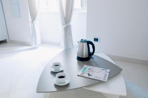 a coffee table with a tea kettle and cups on it at Sfumature Partenopee in Naples