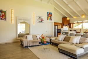 a living room with two couches and a kitchen at Villa Kahia in Teavaro