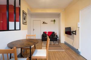 a living room with a table and a couch at Hôtel des Cousines Capucine Apartment in Nancy