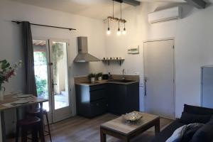 a kitchen and living room with a couch and a table at Gite Studio indépendant au cœur du Luberon in Maubec