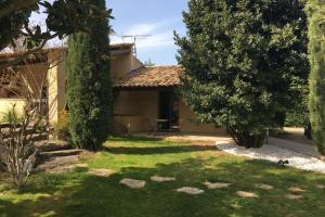 a house with a yard with trees and a patio at Gite Studio indépendant au cœur du Luberon in Maubec