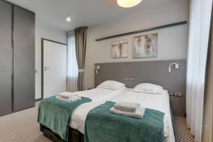 a bedroom with a large bed with towels on it at So Stay Bed & Breakfast - Self Check-in in Gdańsk