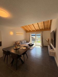 a living room with a table and a couch at Appartement Vue Montagne Vignoble Cosy Valais in Chamoson
