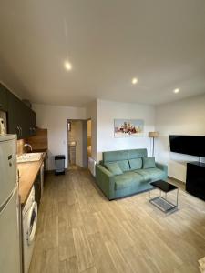 a living room with a green couch in a kitchen at La Punta Geronimi in Porto Pollo