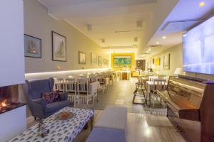 a restaurant with a bar with chairs and a flat screen tv at Carolina Hotel in Pärnu