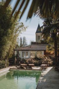 a house with a pool and chairs and a building at Domaine Kaet in Ratenelle