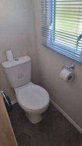 a white toilet in a bathroom with a window at 87 Mountain View, Hafan Y Mor in Afon Wen Junction +13 photos