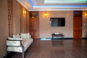 a living room with a couch and a tv on a wall at Kilimont Hotel in Mabire