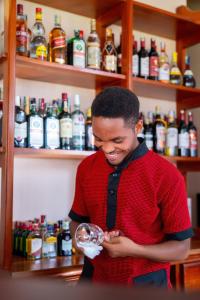 a man standing in a bar drinking from a wine glass at Kilimont Hotel in Mabire
