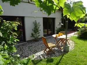 a patio with a table and chairs in a yard at Auszeit Posthausen in Machern