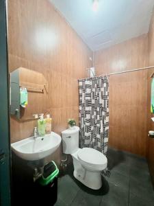 a bathroom with a toilet and a sink at JRC Feel at Home in Puerto Princesa City