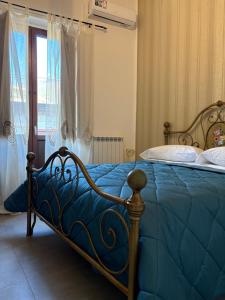 a bedroom with a bed with a blue comforter at Borgo Scorciarini B&B in Piedimonte dʼAlife