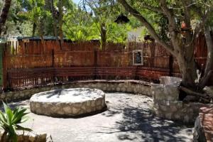 a backyard with a fence and a tree at The Plot West Coast Style Glamping & Accommodation in Jacobs Bay