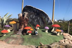 a model of a mushroom house with a man sitting on a hill at The Plot West Coast Style Glamping & Accommodation in Jacobs Bay