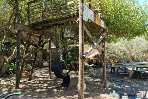 a playground with a tire and a table and trees at The Plot West Coast Style Glamping & Accommodation in Jacobs Bay +14 photos