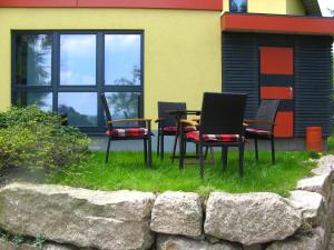 a group of chairs and tables in front of a building at Holiday Home mit Wallbox by Interhome in Eibenstock