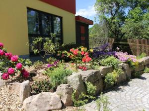 a garden of flowers in front of a building at Holiday Home mit Wallbox by Interhome in Eibenstock