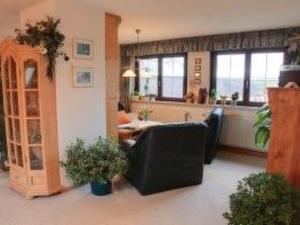 a living room with a couch and a table at Apartment FeWo Panorama by Interhome in Rauenstein