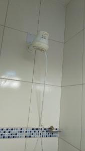 a shower head on the ceiling of a bathroom at Casa Rosa da Ilha - Suíte com Ar-condicionado e Jardim Amplo in Vera Cruz de Itaparica