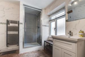 a bathroom with a shower and a sink and a window at 3 Bed in Appledore oc-phoe in Appledore