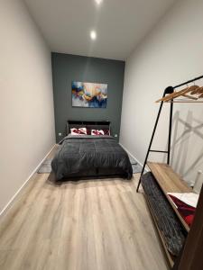 a bedroom with a bed in the corner of a room at HOME 102 Cosy in Lons-le-Saunier