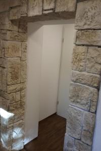 a room with a stone wall and a white door at Apartment Bergnest by Interhome in Bad Gottleuba