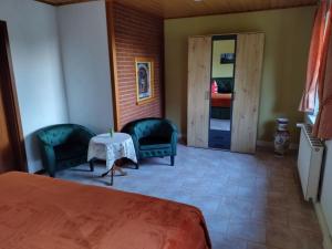 a room with a bed and two chairs and a table at Holiday Home Itzinger by Interhome in Ziesar +27 photos