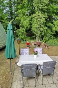 a table with two chairs and a green umbrella at Holiday Home Itzinger by Interhome in Ziesar