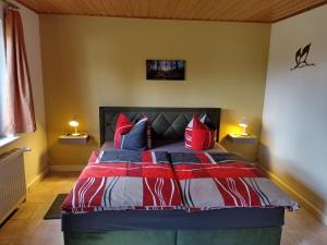 a bedroom with a bed with red and blue pillows at Holiday Home Itzinger by Interhome in Ziesar