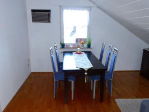 a dining room with a black table and blue chairs at Apartment ApartmentmitAusblick by Interhome in Wörth am Rhein