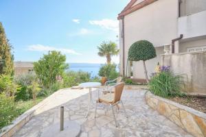 a patio with a table and chairs and a building at Bella Vista Dalmatien in Čelina