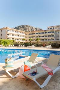 a swimming pool with two chaise lounge chairs and a hotel at Pierre & Vacances Estartit Playa in L'Estartit