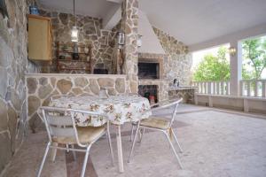 a kitchen with a table and chairs in a stone wall at Bella Vista Dalmatien in Čelina
