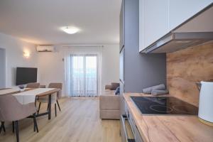 a kitchen and dining room with a table and a kitchen and a living room at Bella Vista Dalmatien in Čelina