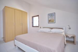 a white bedroom with a large bed and a cabinet at Bella Vista Dalmatien in Čelina +47 photos