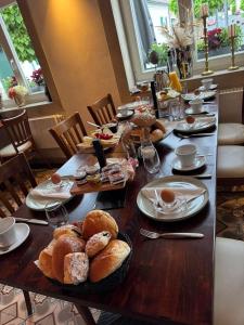 a long wooden table with bread and pastries on it at Restaurant Hotel Laternchen in Cologne