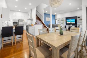 a kitchen and dining room with a wooden table and chairs at Coffs Jetty Beach House in Coffs Harbour