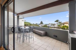 a patio with a table and chairs on a balcony at Coffs Jetty Beach House in Coffs Harbour