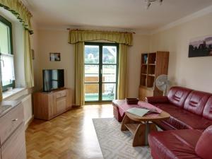a living room with a red couch and a television at Apartment Bastei by Interhome in Kurort Rathen