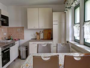 a kitchen with white cabinets and a table and chairs at Apartment Bastei by Interhome in Kurort Rathen