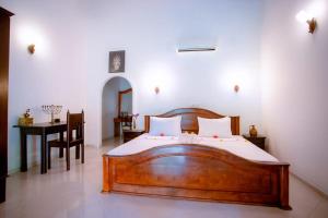 a bedroom with a wooden bed and a table at Villa Silent Harbour in Bentota