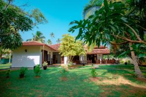 a house with a yard with trees and grass at Villa Silent Harbour in Bentota