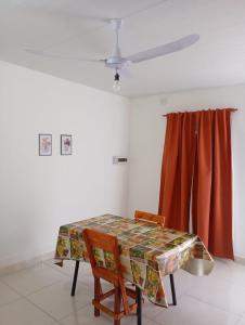 a dining room table with two chairs and a curtain at Dpto Los Pinos in Fernández