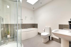a bathroom with a tub and a toilet and a sink at 4 Bed in High Peak oc-dcchb in Chinley +15 photos