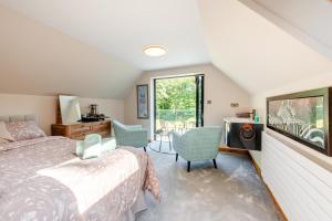 ein Schlafzimmer mit einem Bett, zwei Stühlen und einem Fenster in der Unterkunft 2 Bed in Llanybydder oc-b32255 in Cwrt-newydd