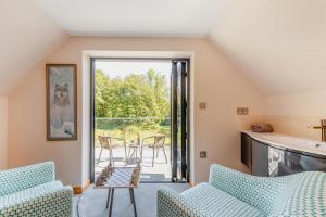 ein Wohnzimmer mit zwei blauen Stühlen und einer Terrasse in der Unterkunft 2 Bed in Llanybydder oc-b32255 in Cwrt-newydd + 29 Fotos